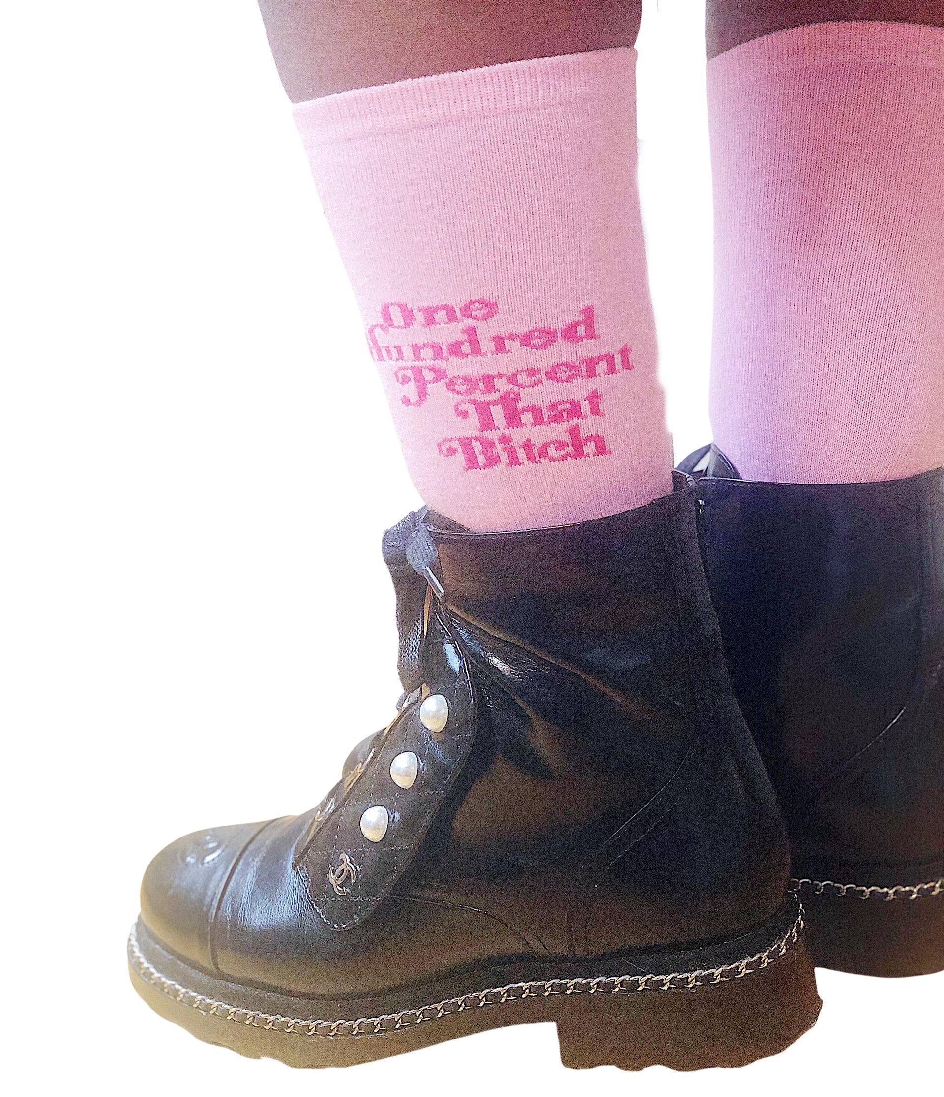 A Black woman wearing boots and pink socks