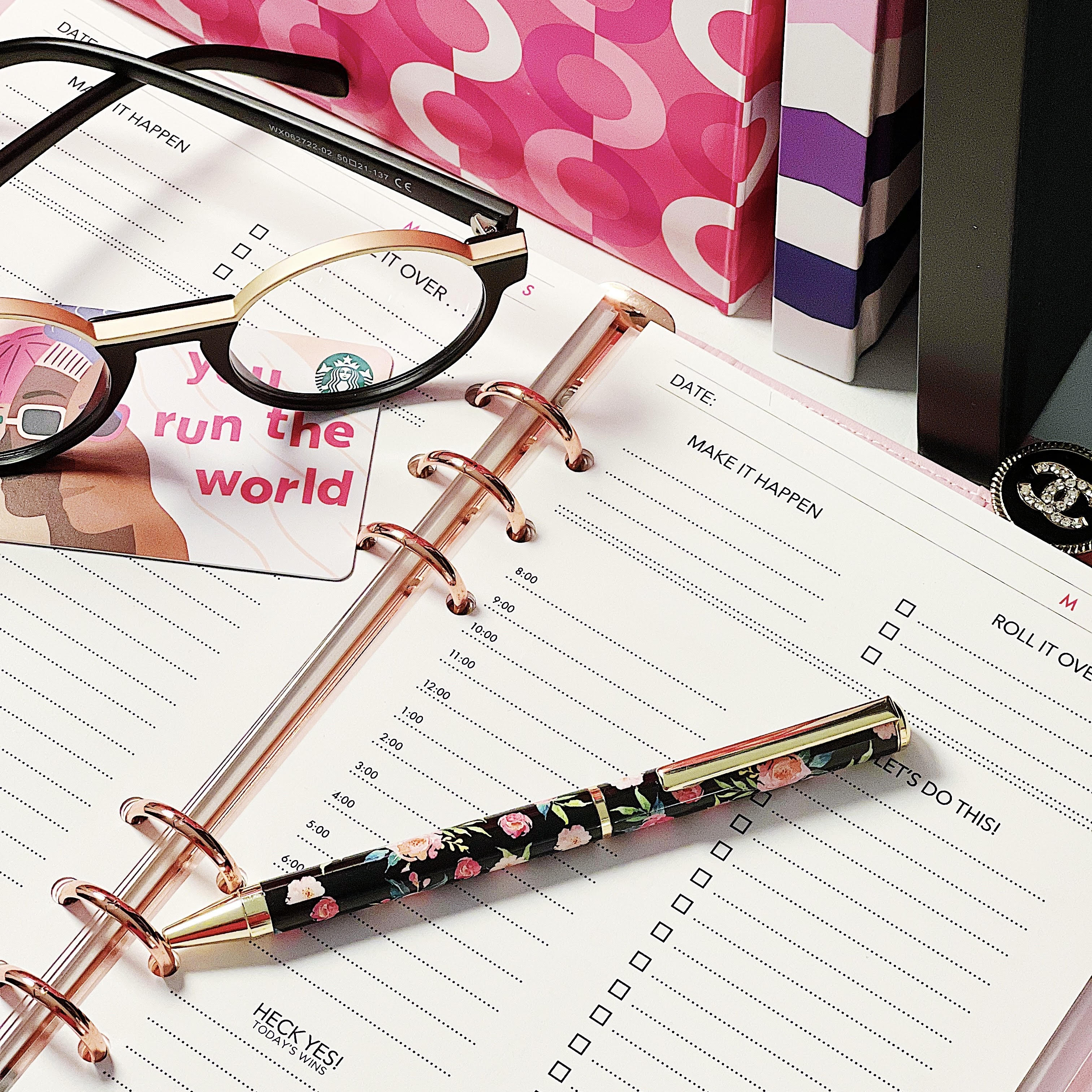 a desk showing a notebook, glasses, and the Future Is female pen