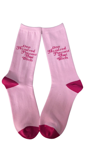 Two pink socks that say One Hundred Percent That Bitch