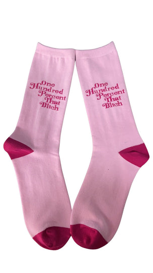 Two pink socks that say One Hundred Percent That Bitch